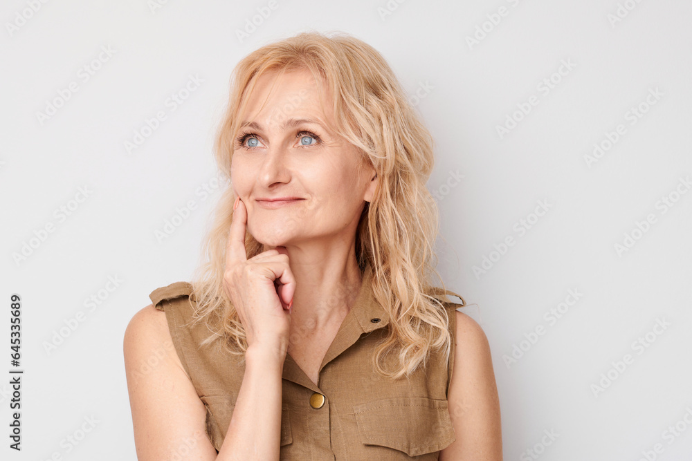 Portrait of clever mature woman touching chin thinking chooses doubts isolated on white studio background with copy space. - obrazy, fototapety, plakaty 