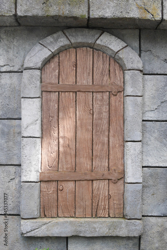 old wooden window in stone wall