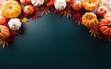 Thanksgiving and Autumn decoration concept made from autumn leaves and pumpkin on dark background. Flat lay, top view with copy space.