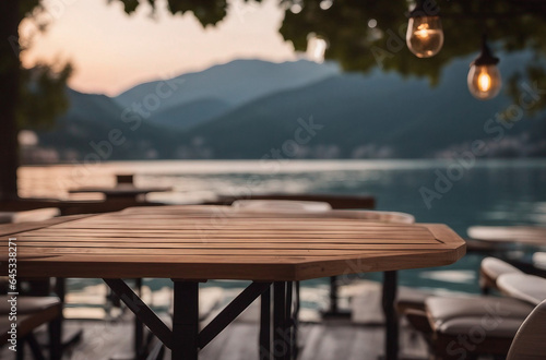 Empty wooden table top with blurred lakeside cafe on a gorgeous Italian lake in the evening vacation