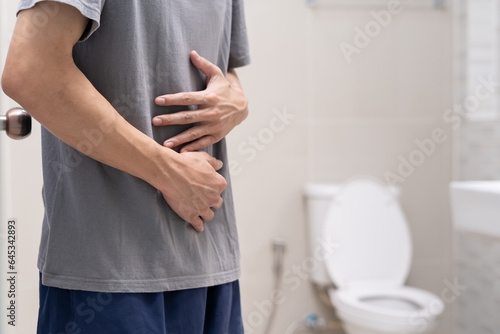 Constipation and diarrhea in bathroom. Hurt man touch belly stomach ache painful. colon inflammation problem, toxic food, abdominal pain, abdomen, constipated in toilet, stomachache, Hygiene.