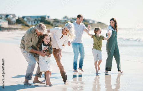 Grandparents  children and big family with play at beach  comic laugh or bonding for love  sunshine or excited on vacation. Mom  dad and kids by sea  waves and freedom on holiday for summer in Spain