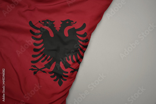 big waving national colorful flag of albania on the gray background.