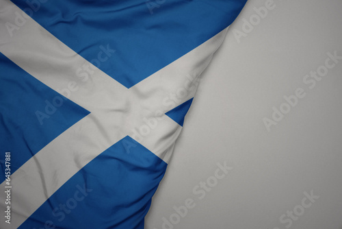 big waving national colorful flag of scotland on the gray background. photo