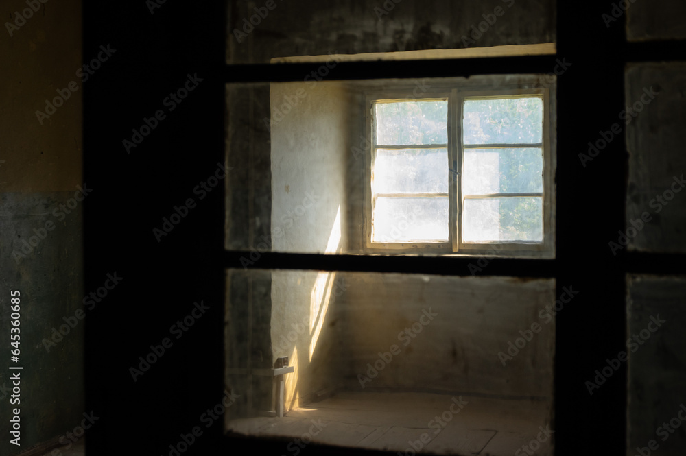 Sunlight entering a dark spooky room through filthy windows in an abandoned house Sunlight entering a dark spooky room through filthy windows in an abandoned house