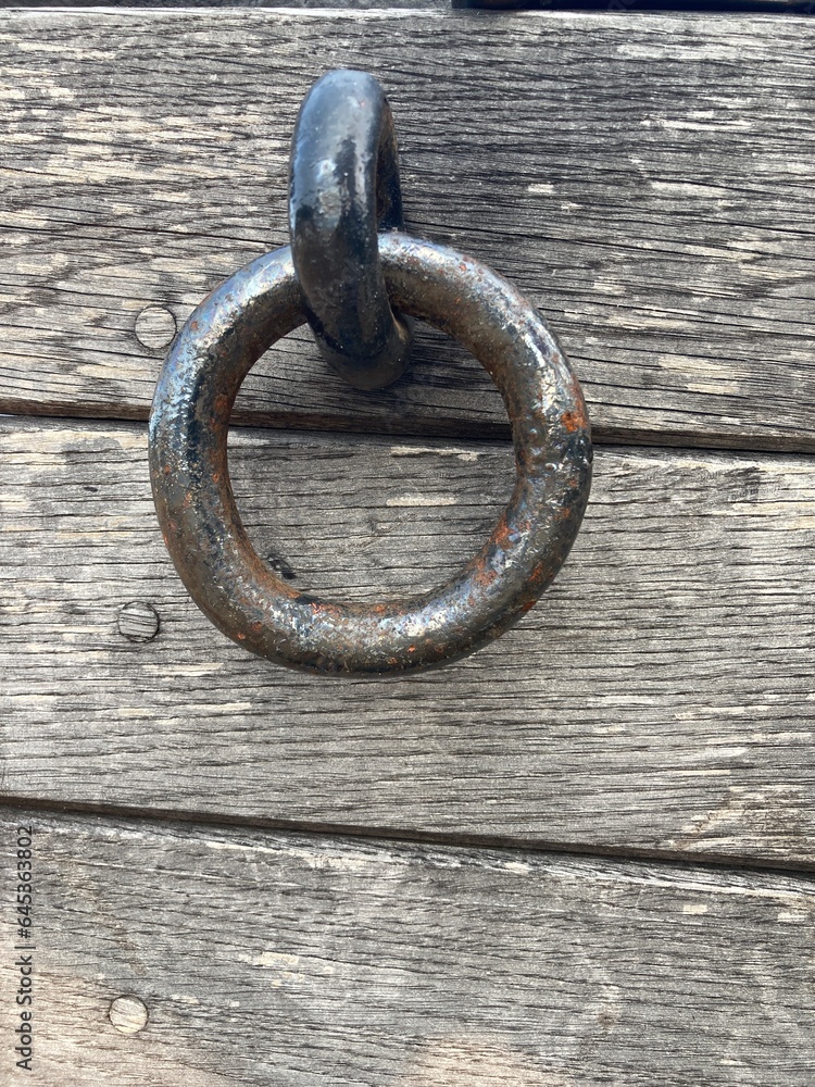 A black metal ring on a wooden wall A black metal ring on a wooden wall