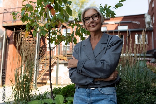 Canvas Print a charming mature woman with gray hair and glasses is dressed in a gray jacket a