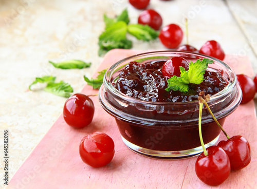 cherry jam in a jar and fresh berries on the table