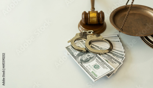 Handcuffs and dollars, scales of justice and judge's hammer on table, legal concept
