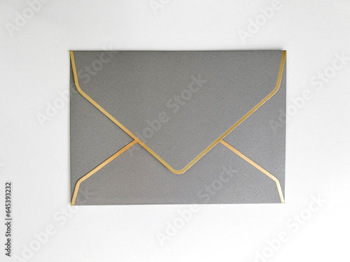 Silver envelope with a white liner for congratulations on a white background. Wedding invitation, for business, postcard. Flat lay, top view, copy space.