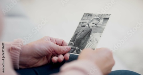 Senior woman  holding and photo with memory with hands and remembering a child in closeup. Retirement  history and elderly person with retro picture in home with nostalgia or thinking about past.