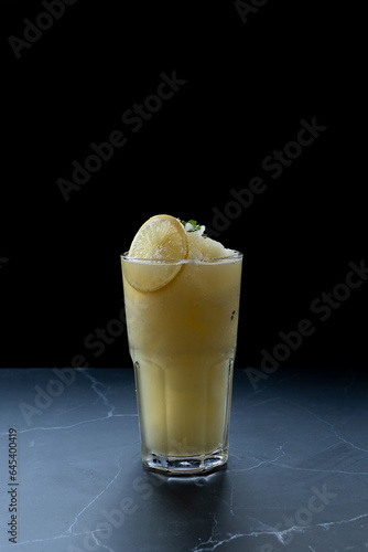 Lemon smoothie, lime, yellow, smoothie drink, mint, refreshing, summer, sour, ice crystals on a black background.