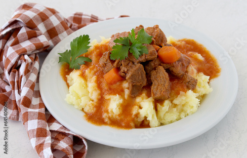 Beef stew with gravy over mashed potatoes