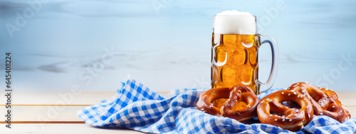 mug of beer and tasty fresh brezels on a wooden table - Oktoberfest background photo