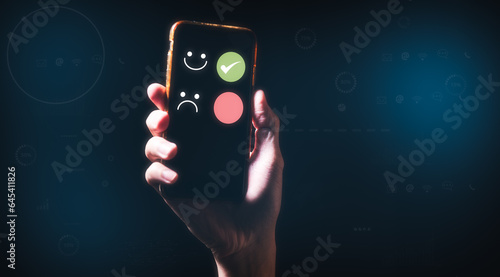Customer service satisfaction survey concept.Business people or customers holding smartphone show satisfaction by pressing face emoticon smile in satisfaction screen. rating very impressed