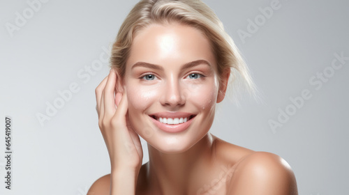 Beauty skin. Head and shoulders of blond woman model, touching glowing, hydrated facial skin, apply toner, skin cream or lotion for healthy look, after shower portrait, white background.