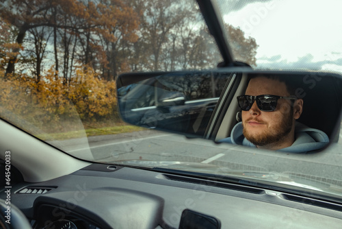 man reflection in car rear mirror