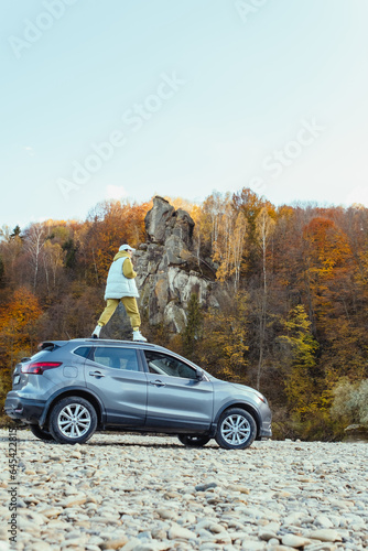 happy woman at car roof enjoying the view of autumn river in carpathian mountains © phpetrunina14