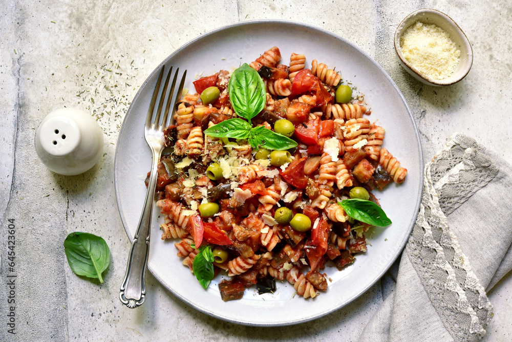 Pasta alla norma, fusilli with eggplants, tomatoes and olives. Traditional dish of sicilian cuisine. Top view with copy space. Pasta alla norma, fusilli with eggplants, tomatoes and olives. Traditional dish of sicilian cuisine. Top view with copy space.