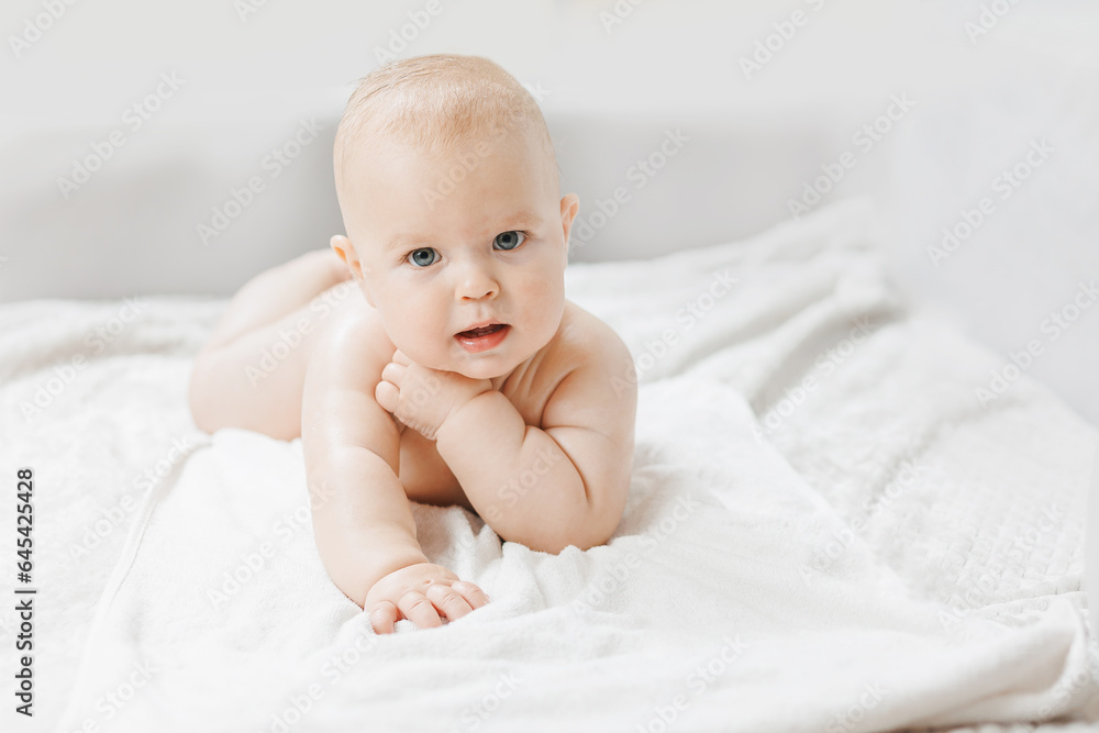Concept lotion for skin of infant. Portrait happy little baby boy after applying body cream