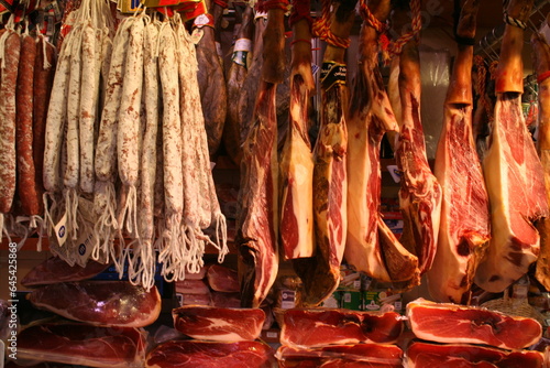 A display of various cuts and types of meat suspended on hooks, tantalizingly awaiting customers’ selection in the store.