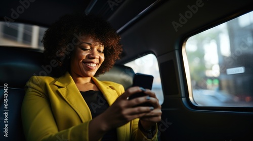 African American business woman using cell phone texting in private car