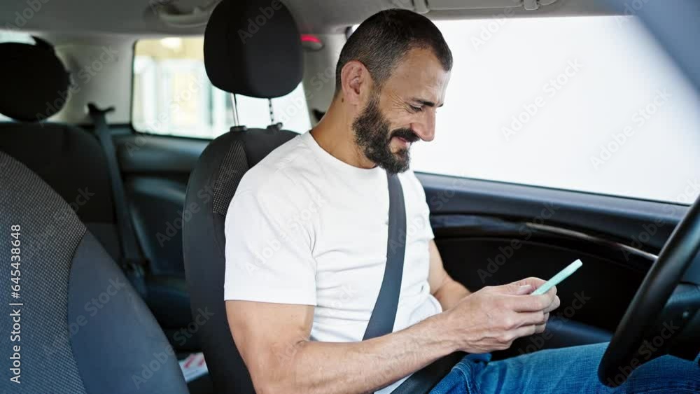Young hispanic man using smartphone sitting on car at street Young hispanic man using smartphone sitting on car at street
