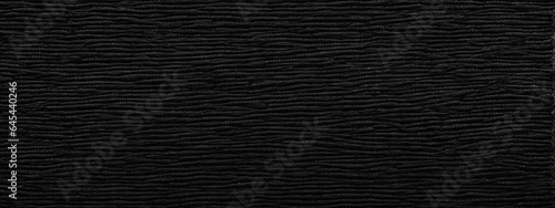 Panoramic close-up texture of natural weave cloth in dark and black color. Fabric texture of natural cotton or linen textile material. Black fabric wide background.