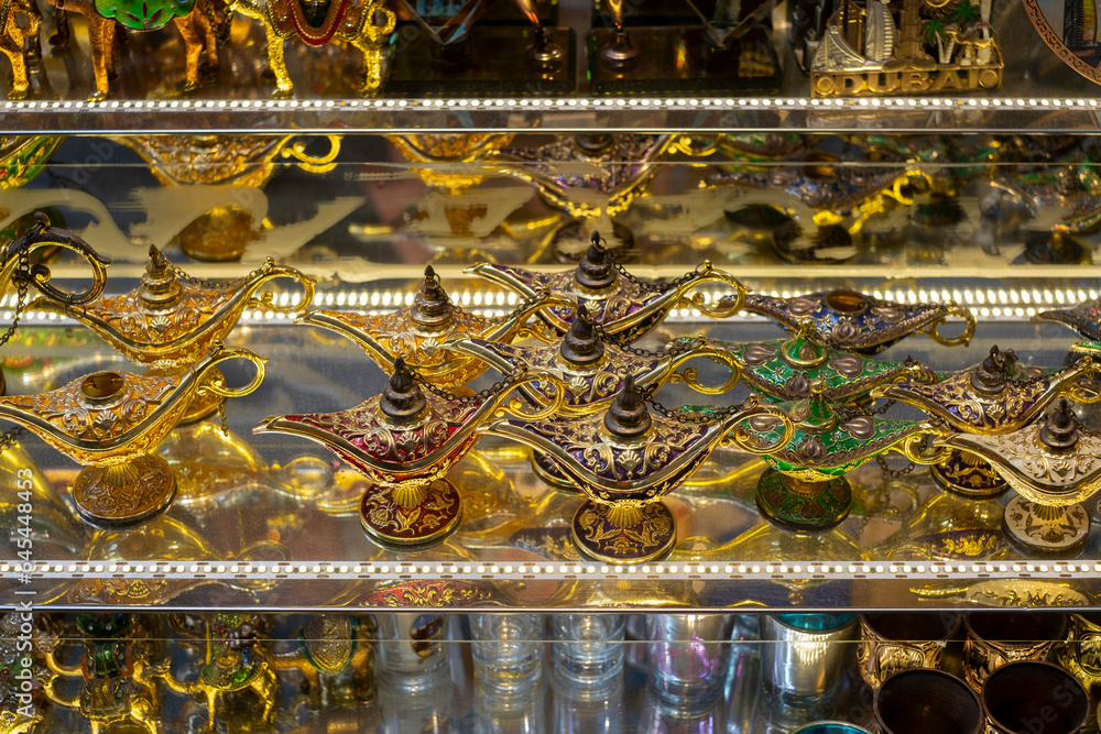 Many shiny golden souvenir lamps at local market. Dubai, UAE.