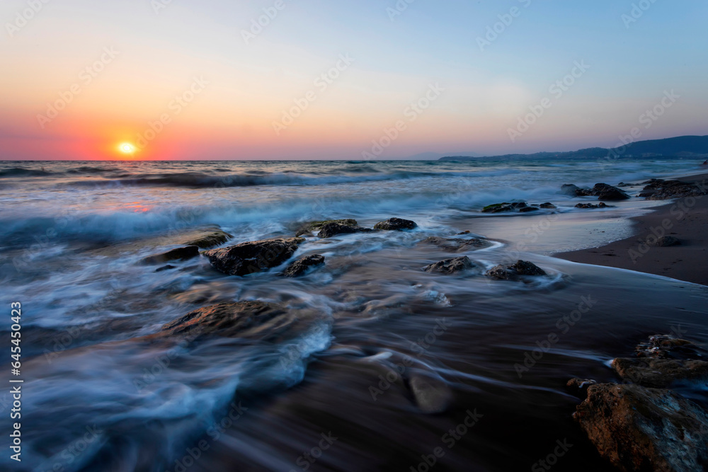Obraz premium A seascape photographed with a long exposure technique at sunset.
