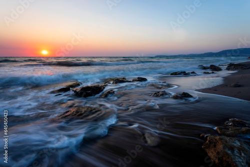 A seascape photographed with a long exposure technique at sunset. © serkanmutan