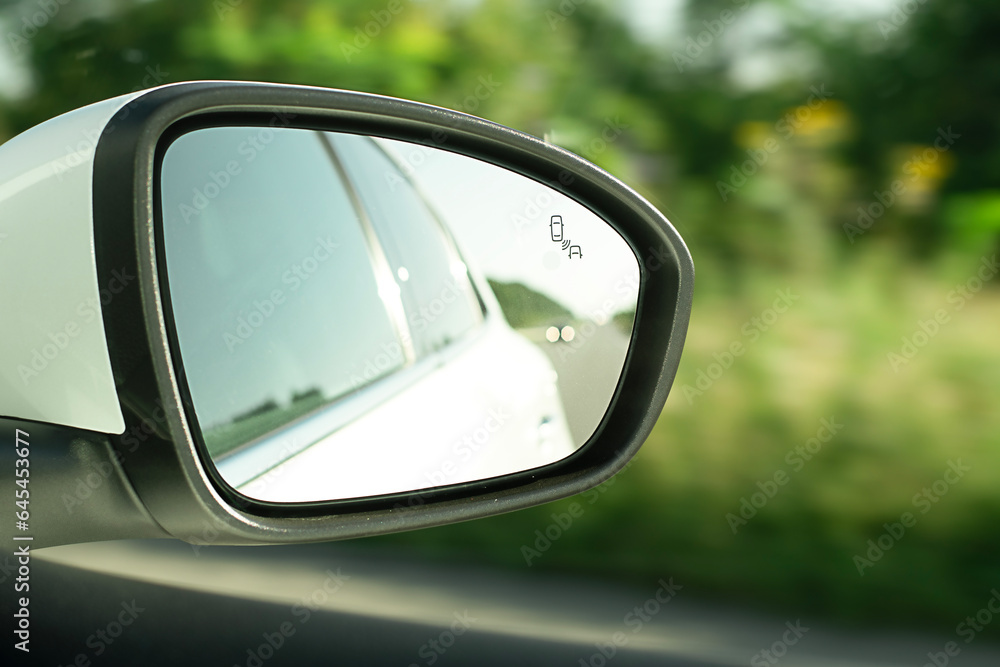 Rear view mirror, close-up, with reflection of a white car when the car is moving. An essential element for driving safety.