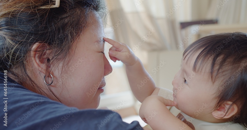 Closeup happy asian family little cute toddler daughter girl playing looking at mother enjoy spending time together with love in living room, Concept of love relationship and motherhood Closeup happy asian family little cute toddler daughter girl playing looking at mother enjoy spending time together with love in living room, Concept of love relationship and motherhood