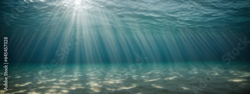underwater background deep blue sea and beautiful light rays with sandy floor