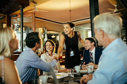 Diverse group of business coworkers having a meeting in a cafe or bar photo