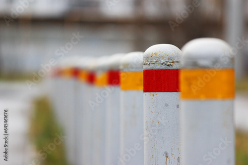 gray restrictive bollards with red and yellow stripes to limit the passage of cars. Anti-terrorist design photo