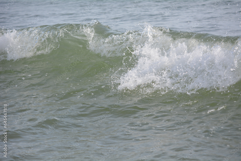 Ocean waves crashing on sandy beach. Sea waves breaking on shore. Nature splash on summer day. Sea wave crashing on beach. Summer holidays concept. Splashing sea water with foam. Ocean waves crashing on sandy beach. Sea waves breaking on shore. Nature splash on summer day. Sea wave crashing on beach. Summer holidays concept. Splashing sea water with foam.