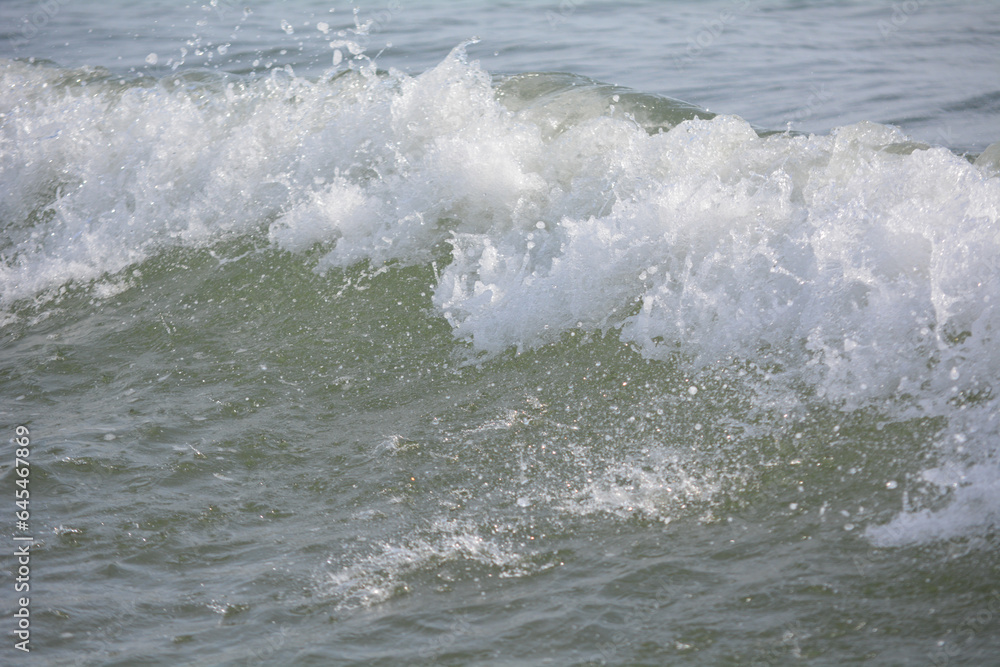 Ocean waves crashing on sandy beach. Sea waves breaking on shore. Nature splash on summer day. Sea wave crashing on beach. Summer holidays concept. Splashing sea water with foam. Ocean waves crashing on sandy beach. Sea waves breaking on shore. Nature splash on summer day. Sea wave crashing on beach. Summer holidays concept. Splashing sea water with foam.