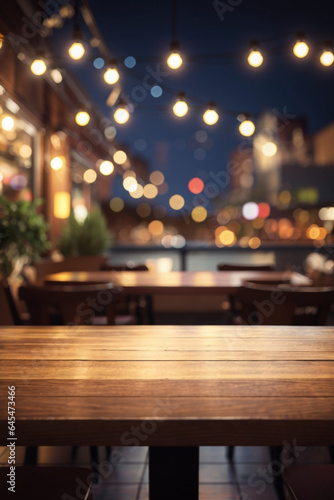 Empty wooden table top with lights bokeh on blur restaurant background.