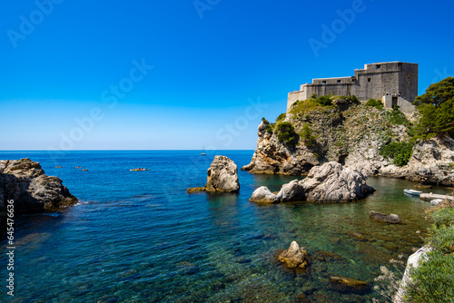 view of the touristic place, sea beach and boats near the old fortress in Dubrovnik city, Croatia, tourism and summer travel concept