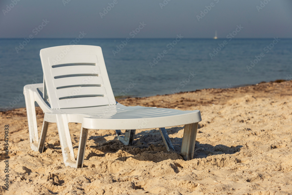 white plastic lounger on the background of the sea white plastic lounger on the background of the sea