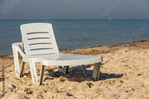 white plastic lounger on the background of the sea