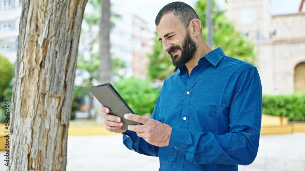 Young hispanic man smiling confident using touchpad at park Young hispanic man smiling confident using touchpad at park