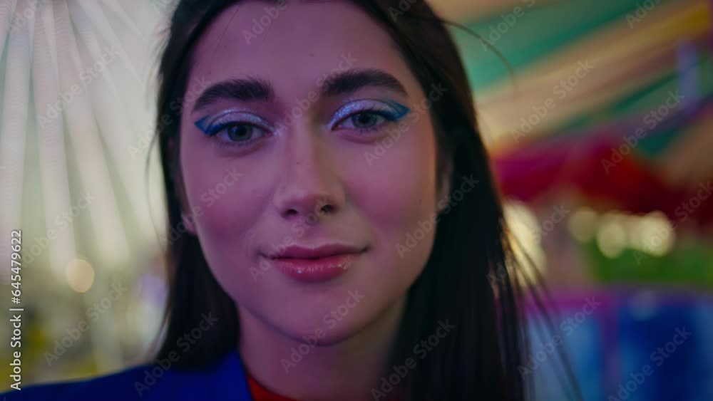 Cheerful girl enjoying luna park closeup. Beautiful party model looking camera