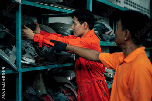 Mechanic worker inspect spare vehicle parts stored in inventory at automotive service. Reusing car components, optimizing resource and availability of spare part for repair and maintenance. Oxus photo