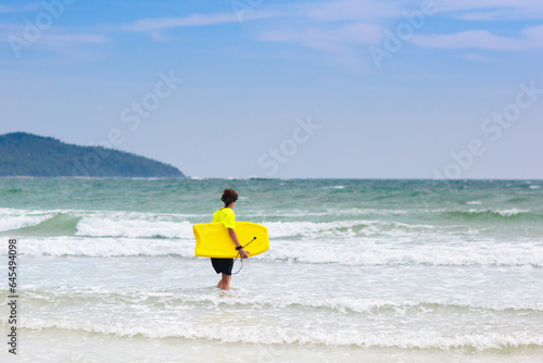 Surfer on tropical beach. Boy surfing.