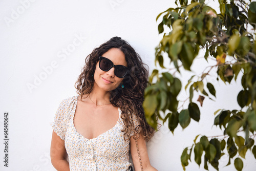 Stylish young girl: 26 year old brown-haired beauty posing in front of a white wall.