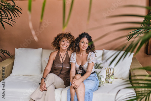 Relaxing Moments: Mother and Daughter Posing in Hotel Lobby Wicker Chair