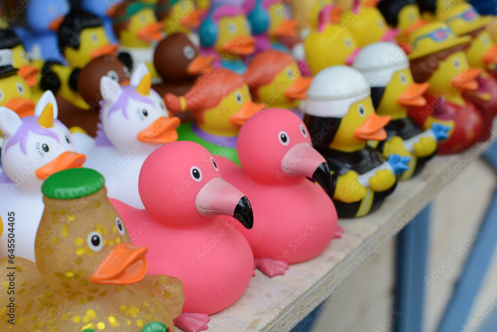 Bathing ducks in different shapes and costumes on a store counter.