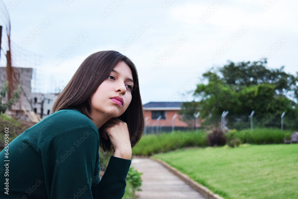 Chica joven meditando al aire libre, mujer analizando sus pensamientos para tomar decisiones importantes.